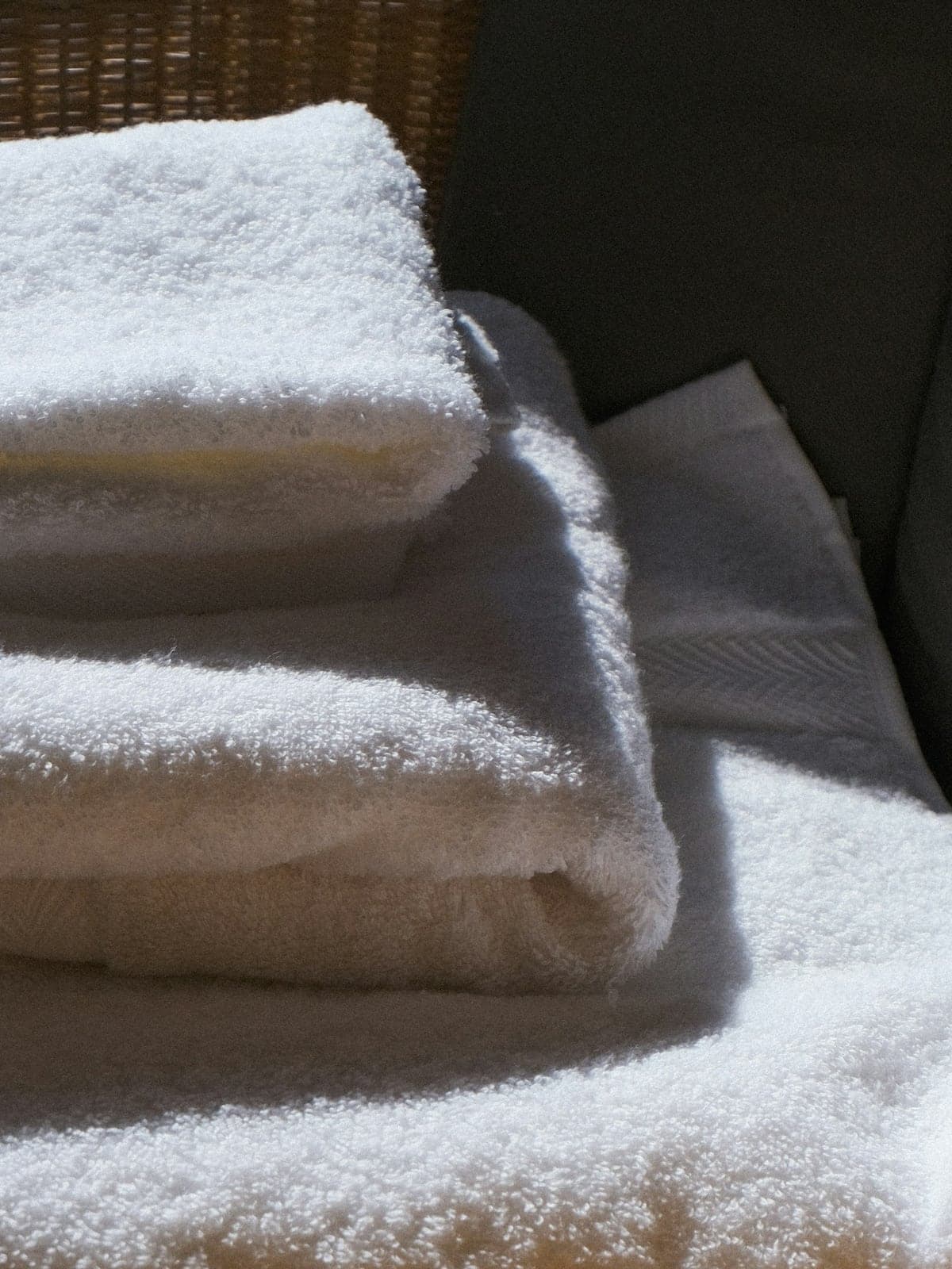 Serviettes blanches pliées sur un fauteuil en rotin